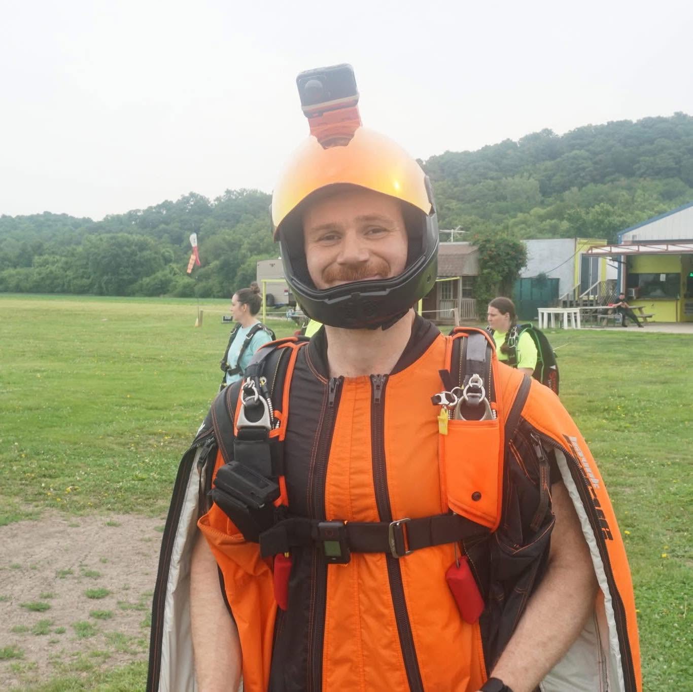 Aryeh Goldman in wingsuit gear and helmet at a dropzone.